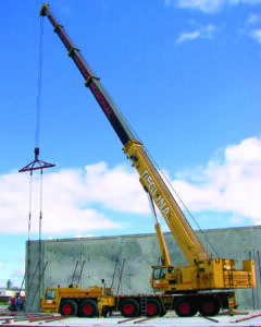 Crane raising a wall as part of the tilt construction of an industrial building in Ottawa