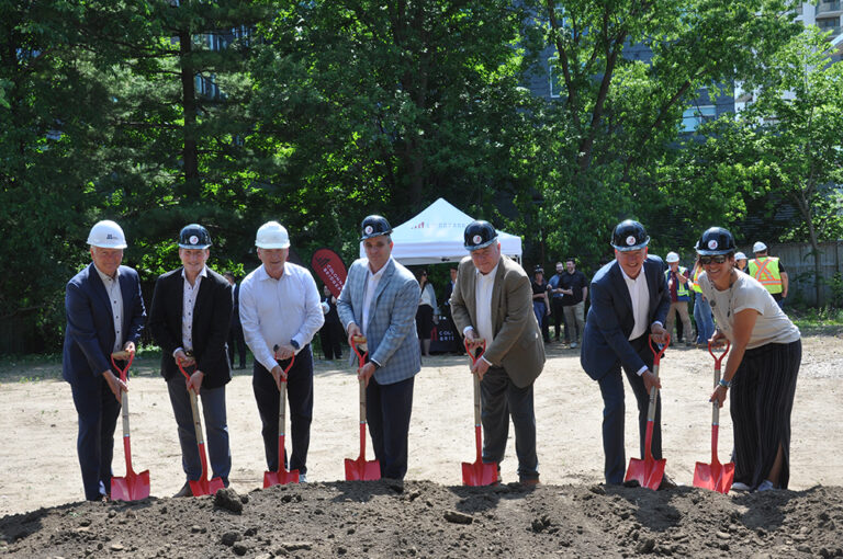 eight individuals with shovels in ceremonial groundbreaking